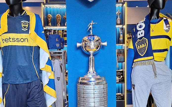 Boca Juniors merchandise and trophy display at La Bombonera Museum.