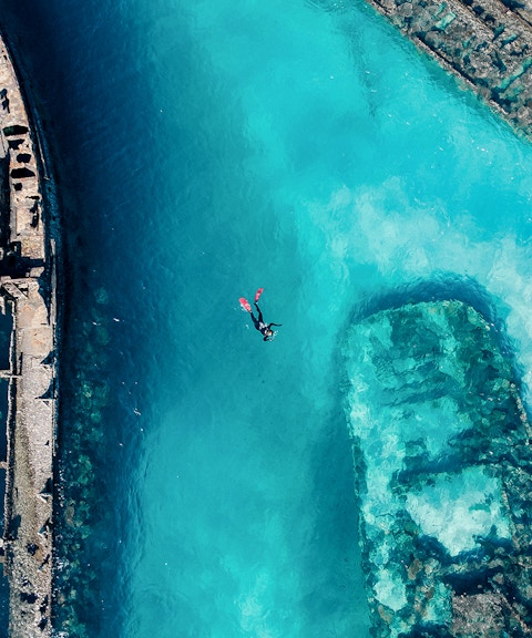 Snorkeler exploring shipwrecks in clear waters of Moreton Island, Australia.