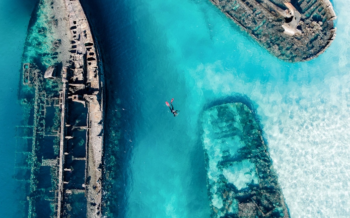 Snorkeler exploring shipwrecks in clear waters of Moreton Island, Australia.