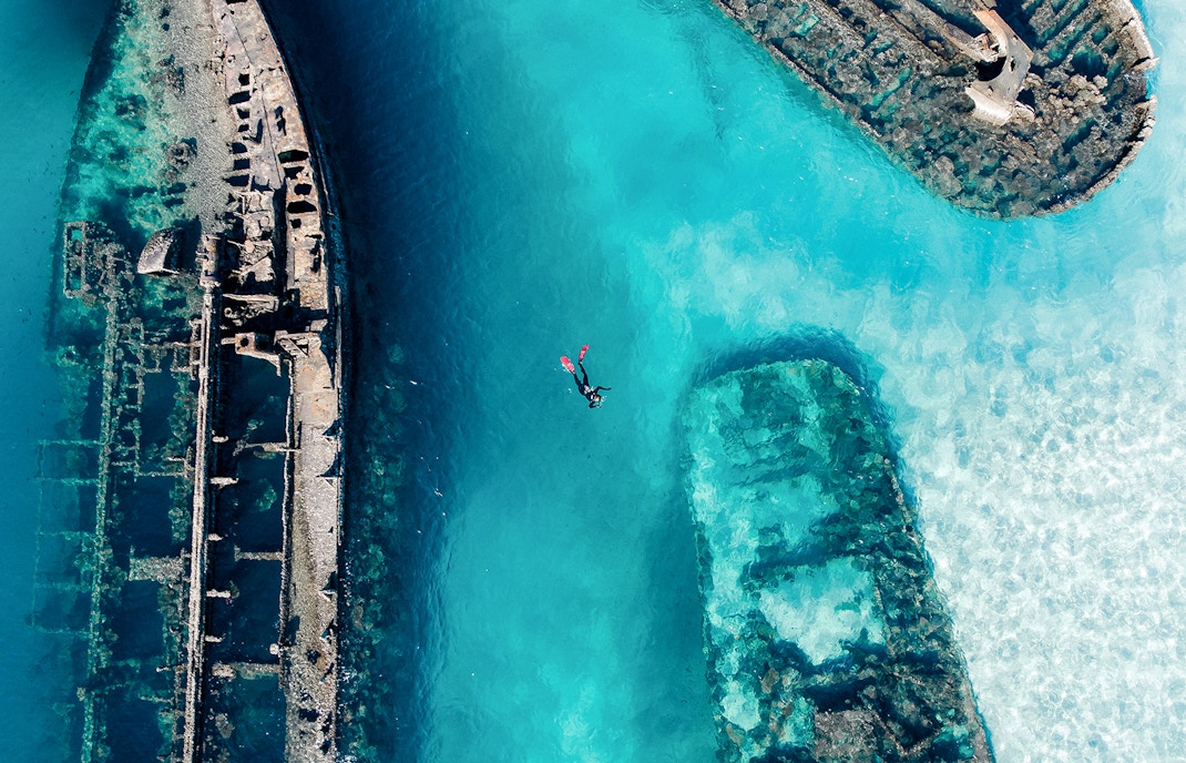 Snorkeler exploring shipwrecks in clear waters of Moreton Island, Australia.