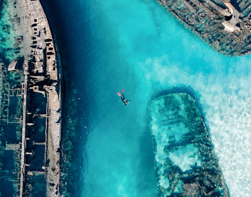 Snorkeler exploring shipwrecks in clear waters of Moreton Island, Australia.