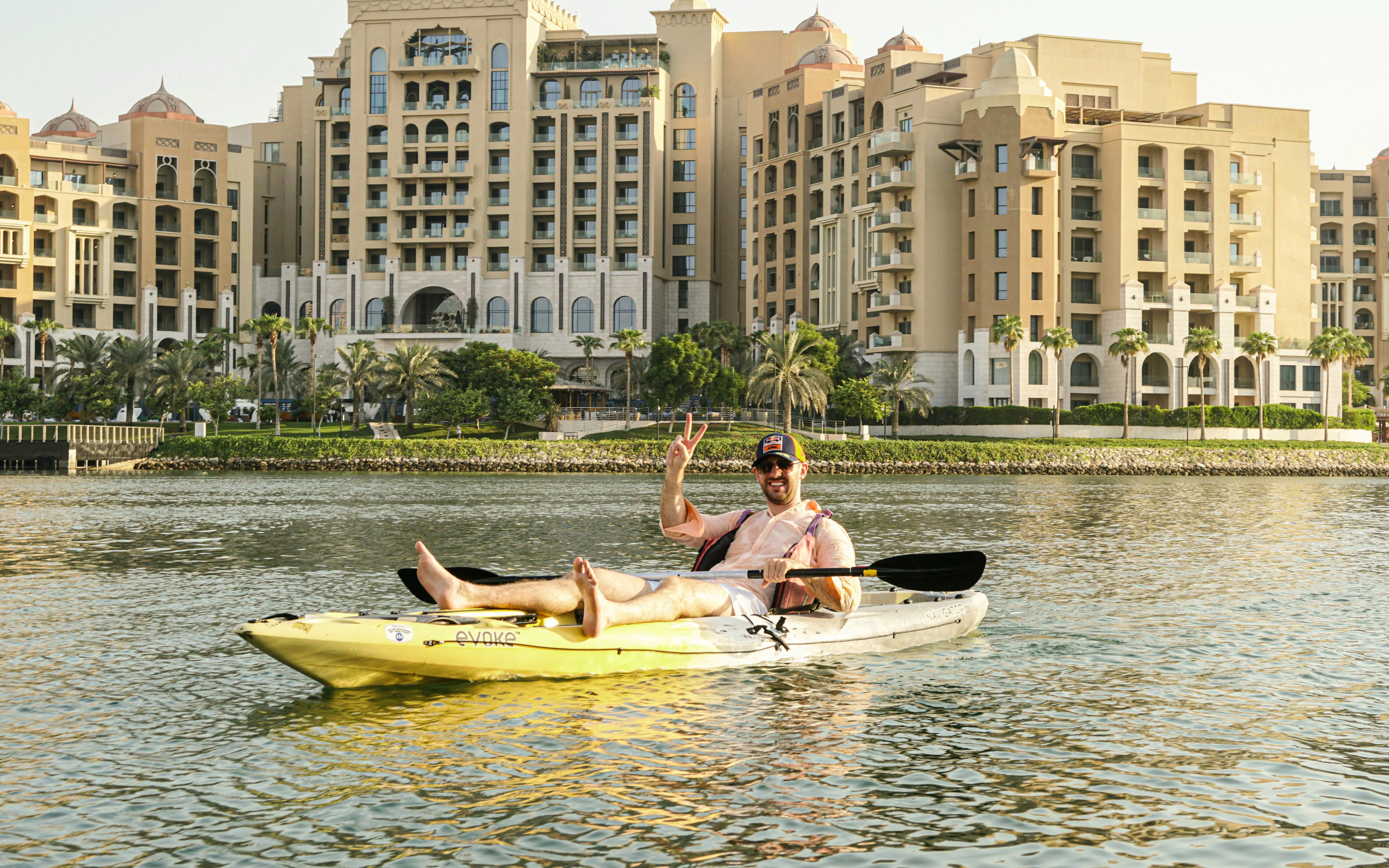 Kayaker on The Pearl Guided Kayak Tour in Doha with waterfront buildings in the background.