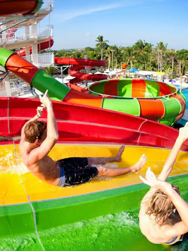 Visitors enjoying colorful water slides at Splash Waterpark, Bali.