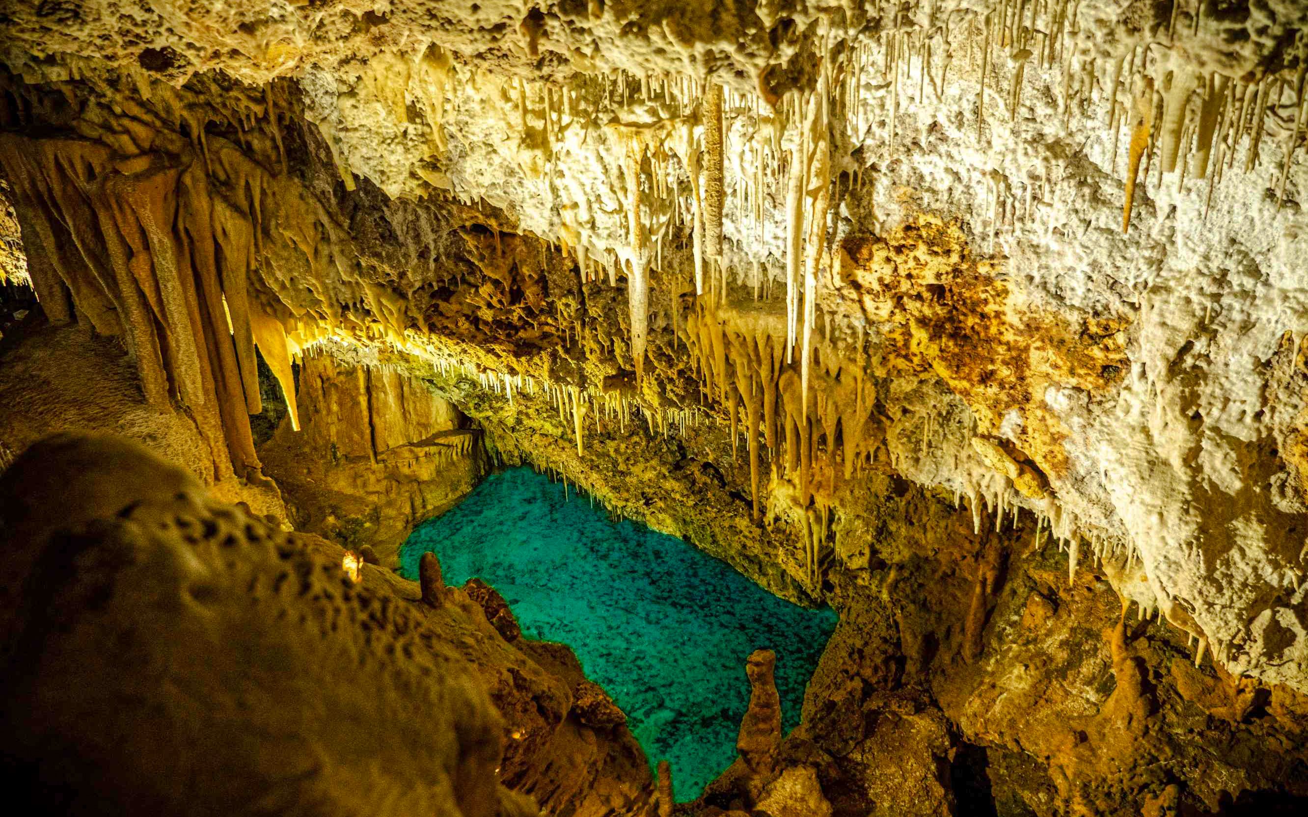 Stalactites and turquoise pool inside Hams Caves, Mallorca.