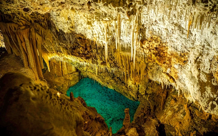Stalactites and turquoise pool inside Hams Caves, Mallorca.
