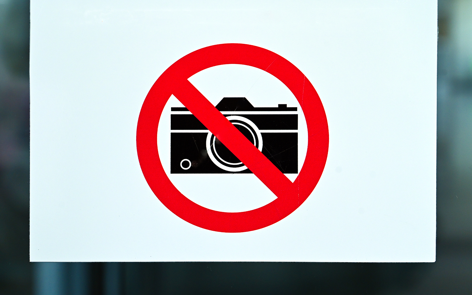 Camera prohibited sign with a red circle and slash.