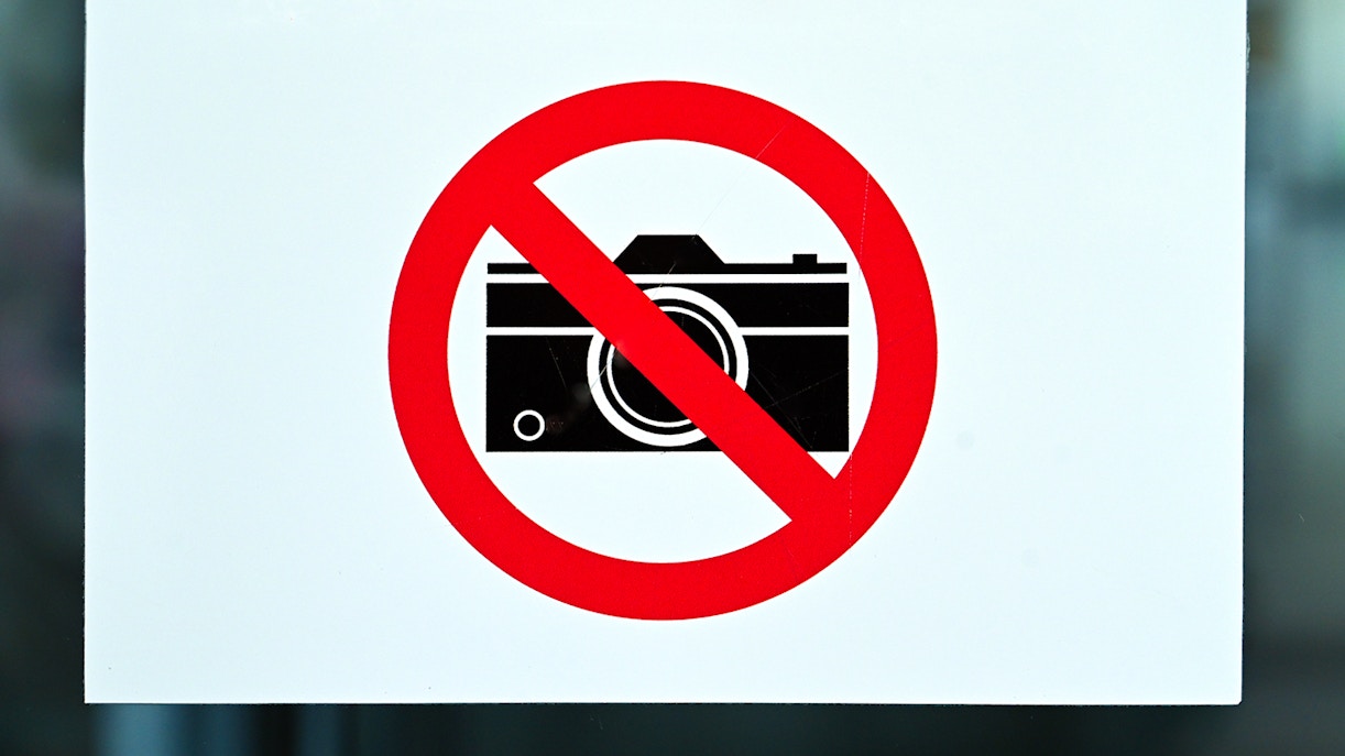 Camera prohibited sign with a red circle and slash.