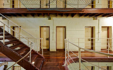 Fremantle Prison interior with cell doors and metal staircase.