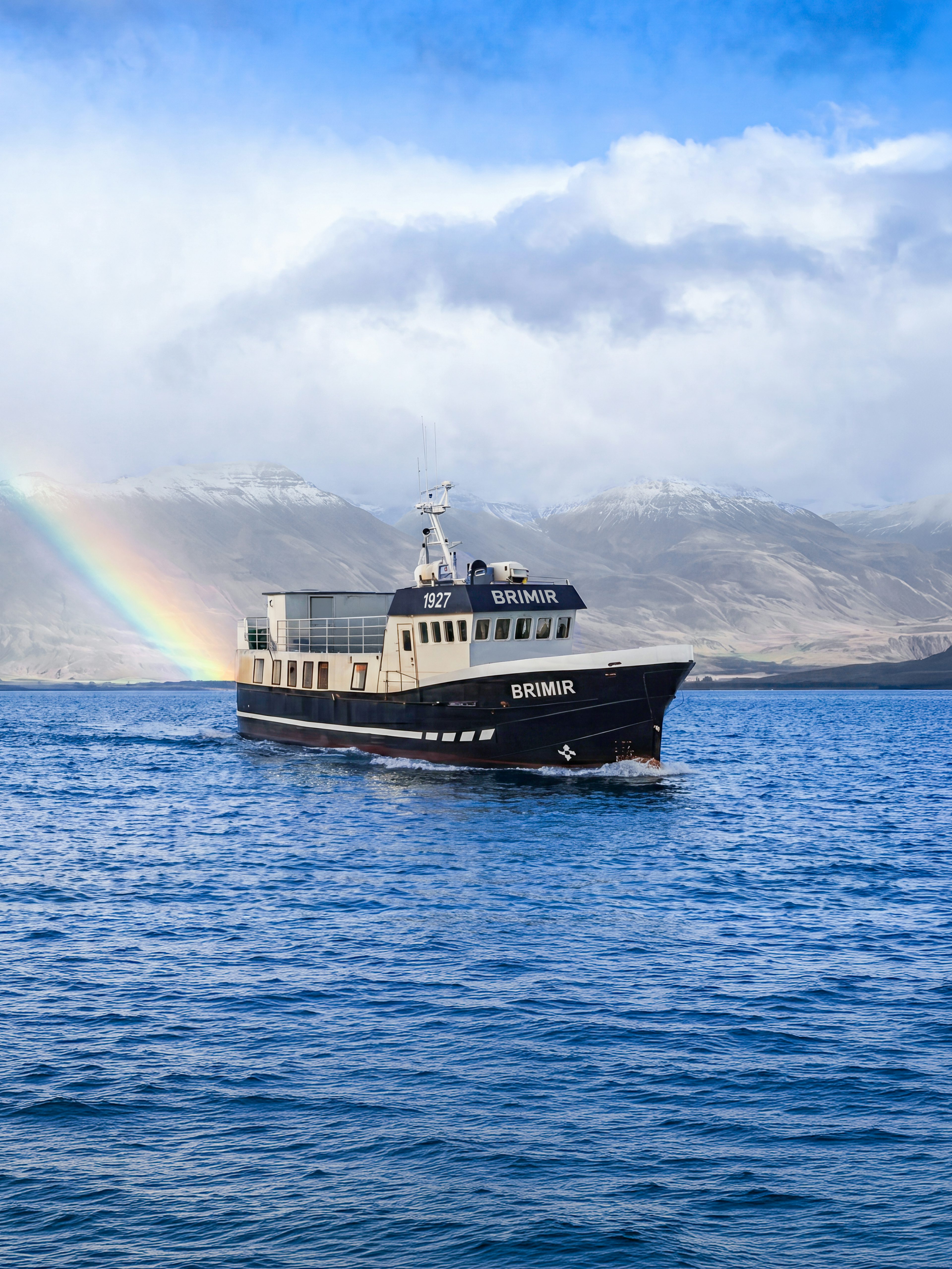 Boat on Eyjafjörður with rainbow, Akureyri whale watching tour.