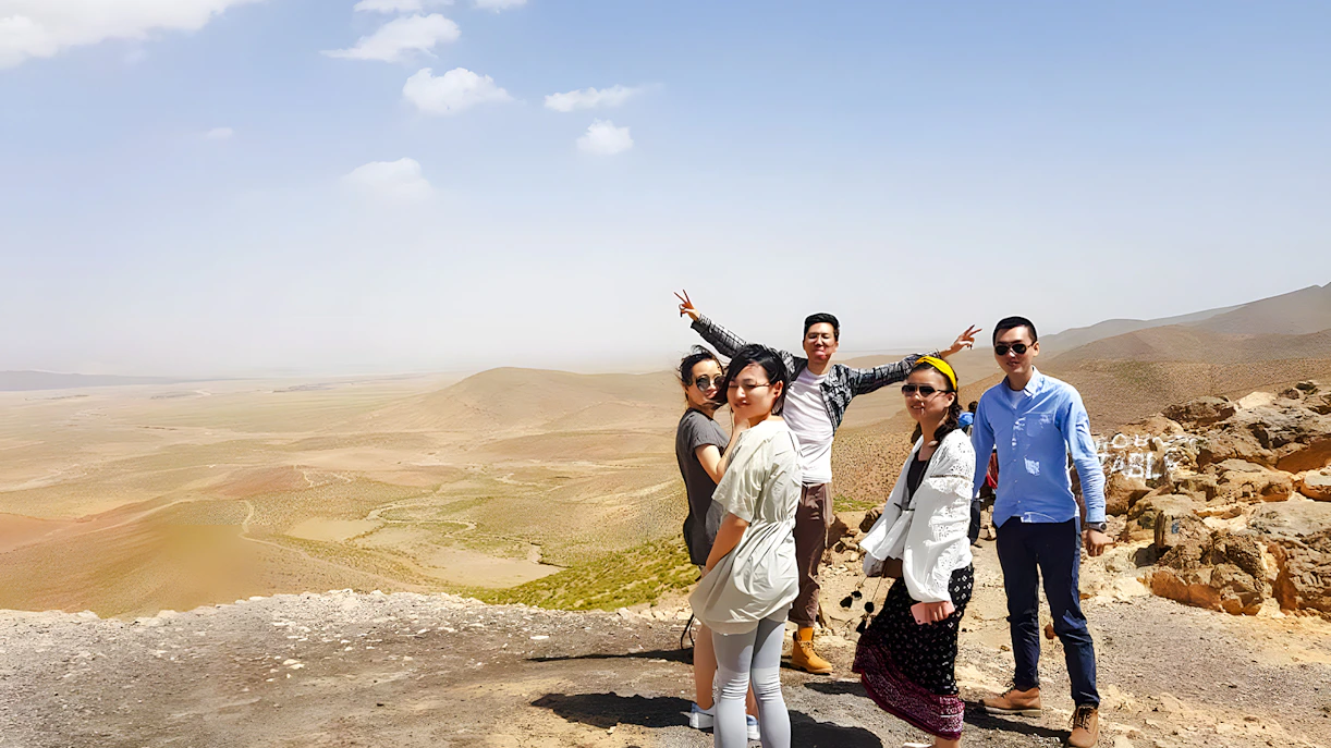 Group posing in Agafay Desert, Marrakech with expansive desert landscape.