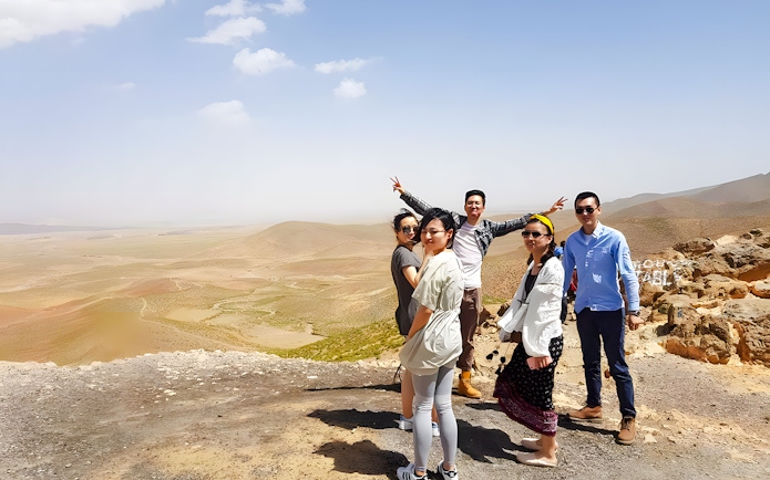 Group posing in Agafay Desert, Marrakech with expansive desert landscape.