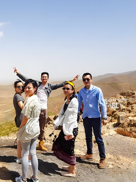 Group posing in Agafay Desert, Marrakech with expansive desert landscape.