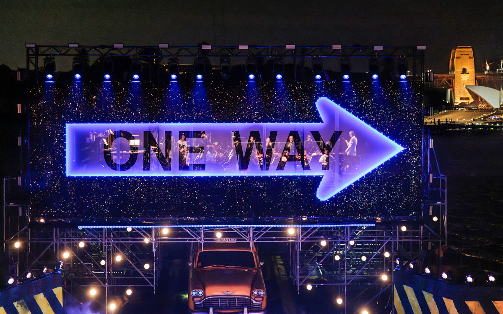 Guys & Dolls performance with illuminated 'One Way' sign on Sydney Harbour stage