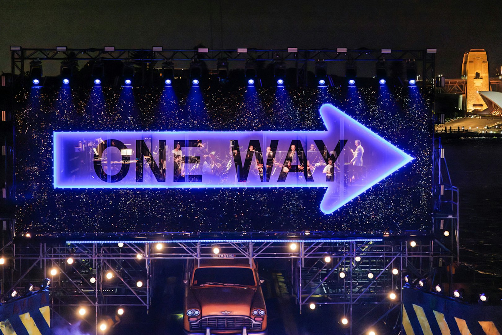 Guys & Dolls performance with illuminated 'One Way' sign on Sydney Harbour stage
