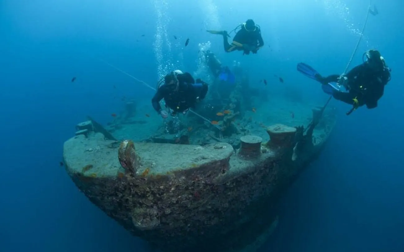 Scuba divers exploring a shipwreck in Sharm El Sheikh.
