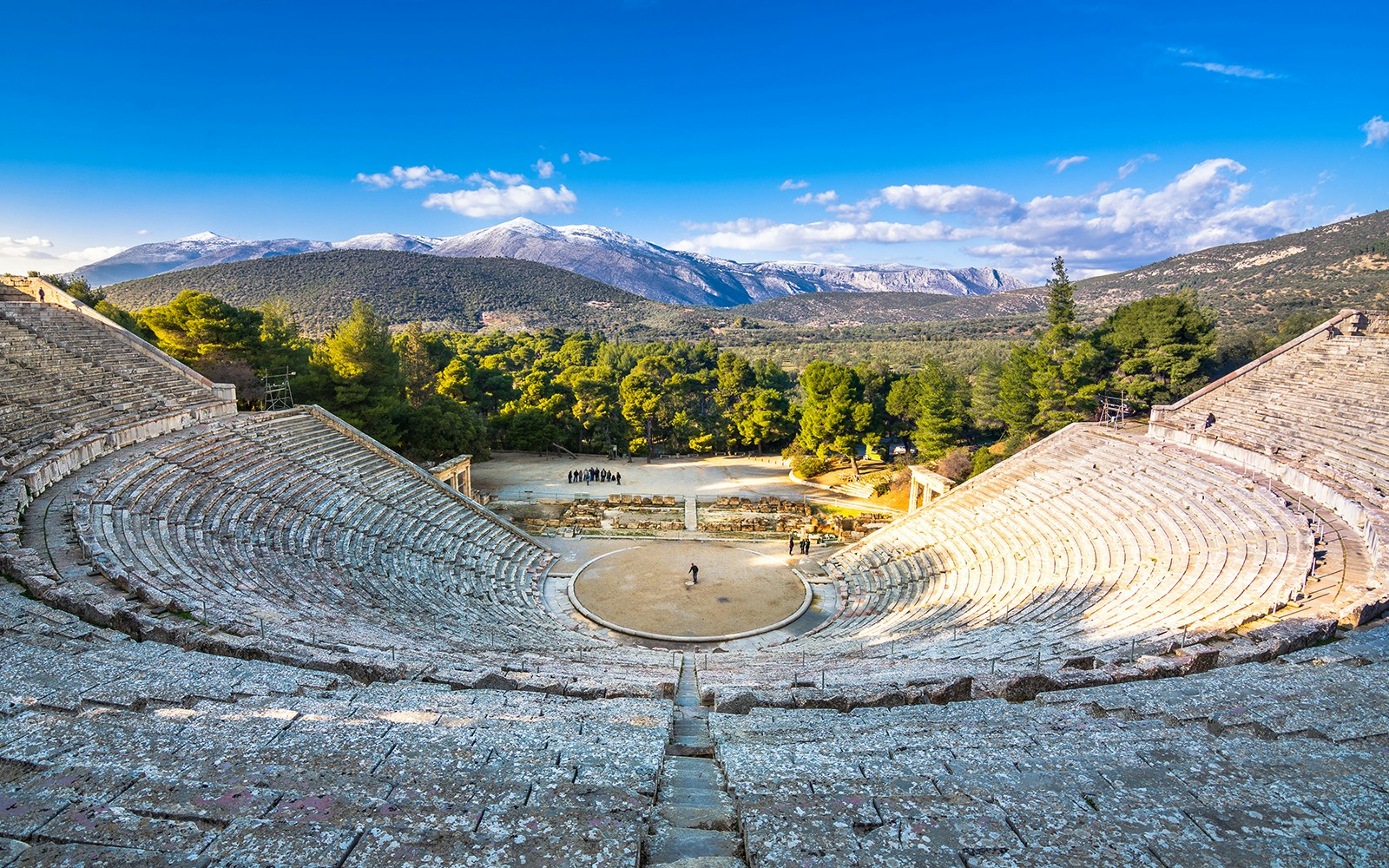 Ancient Epidaurus theater with mountainous backdrop on Nafplio-Mycenae-Epidaurus Day Tour from Athens.