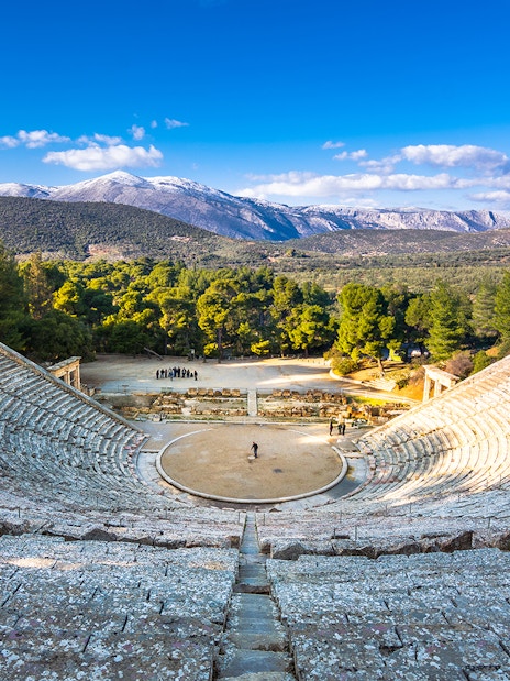 Ancient Epidaurus theater with mountainous backdrop on Nafplio-Mycenae-Epidaurus Day Tour from Athens.