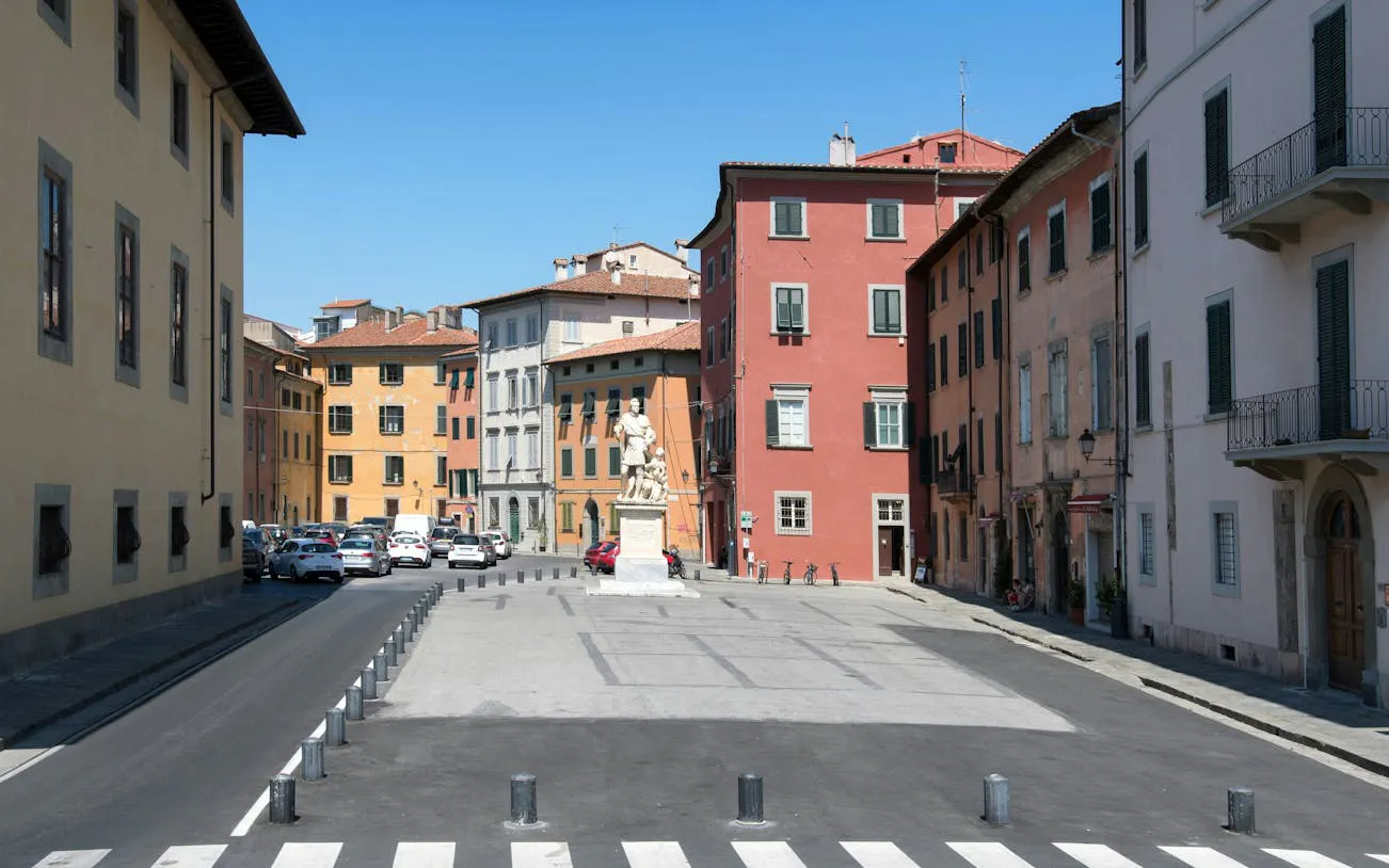 Pisa city square with colorful buildings and a central statue, ideal for a self-guided exploration game.