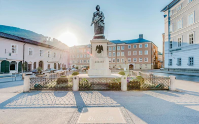 Mozart statue in Salzburg's Mozartplatz with surrounding historic buildings.