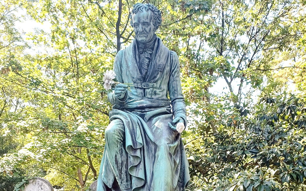 Statue holding flowers in Père Lachaise Cemetery, France.