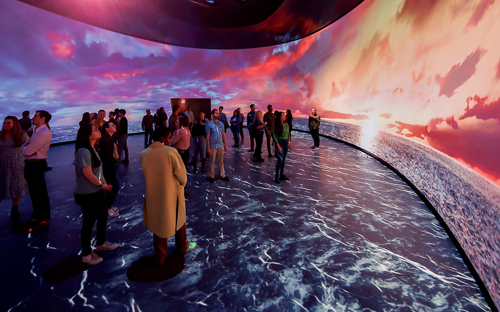 American Museum of Natural History exhibit featuring illuminated globe and visitors exploring displays.