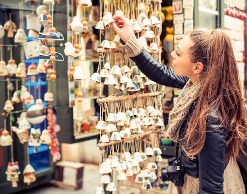 Woman browsing ceramic souvenirs at a market stall.