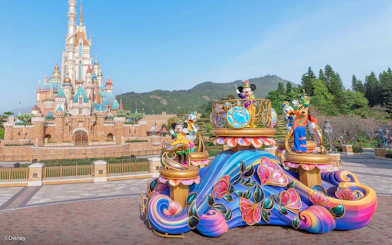 Parade float with characters in front of castle at Disneyland Hong Kong.