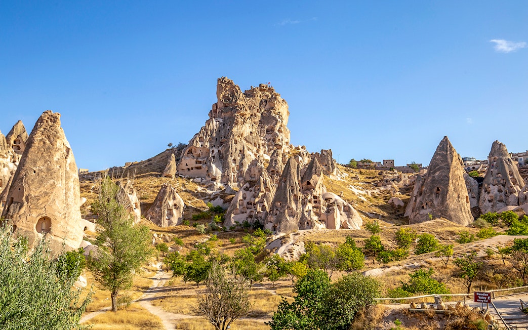 Uchisar Castle rock formations in Cappadocia, Turkey, under a clear blue sky.