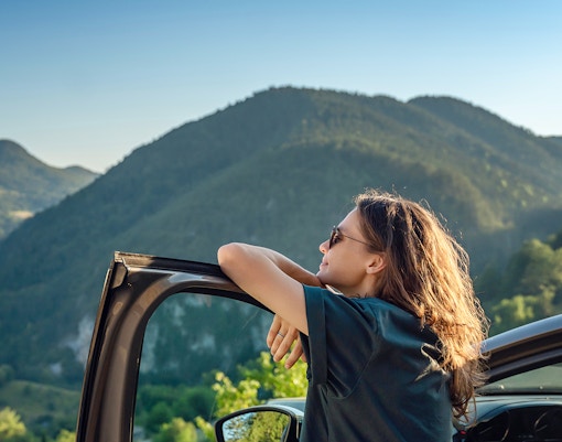 Person getting out of their car to enjoy the views in between the mountains
