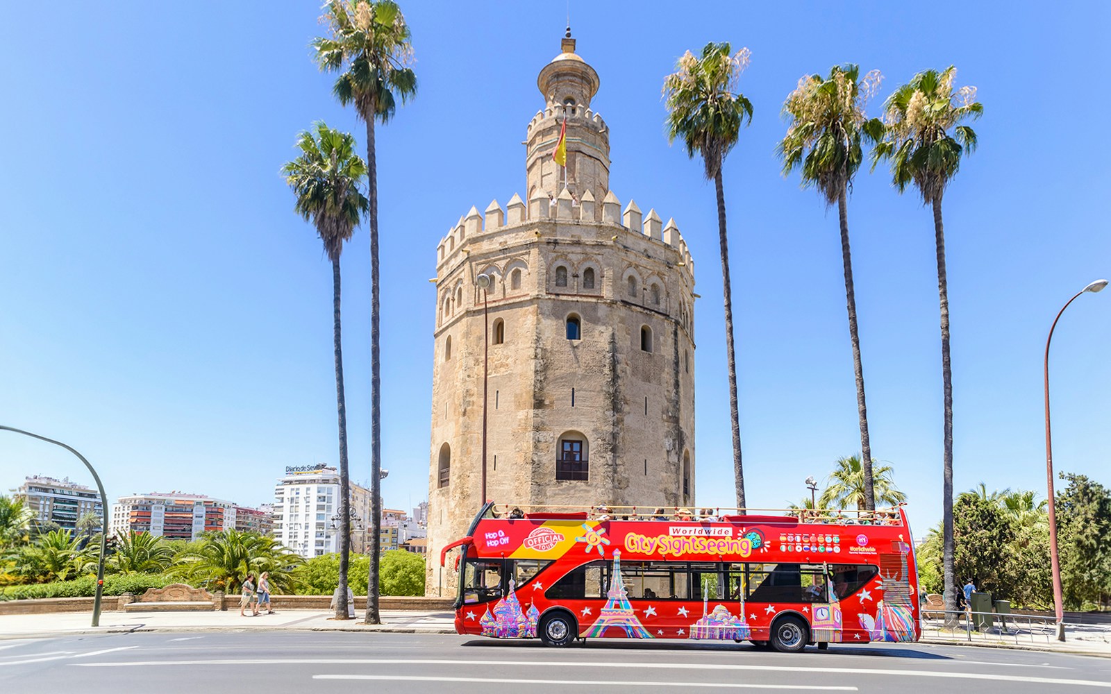 Hop-On-Hop-Off bus in front of Torre del Oro, Seville.