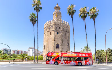 Hop-On-Hop-Off bus in front of Torre del Oro, Seville.