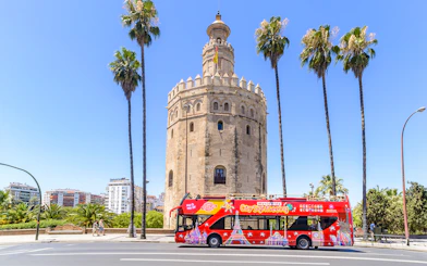Hop-On-Hop-Off bus in front of Torre del Oro, Seville.