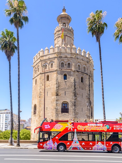 Hop-On-Hop-Off bus in front of Torre del Oro, Seville.