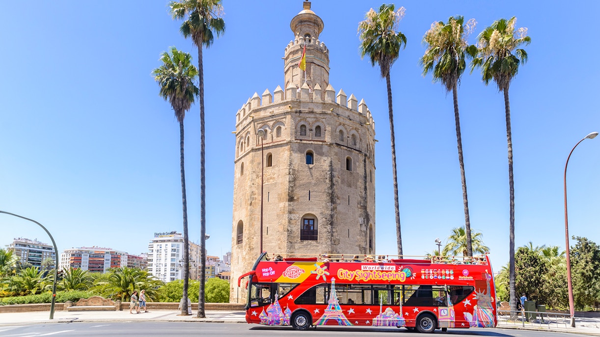 Hop-On-Hop-Off bus in front of Torre del Oro, Seville.