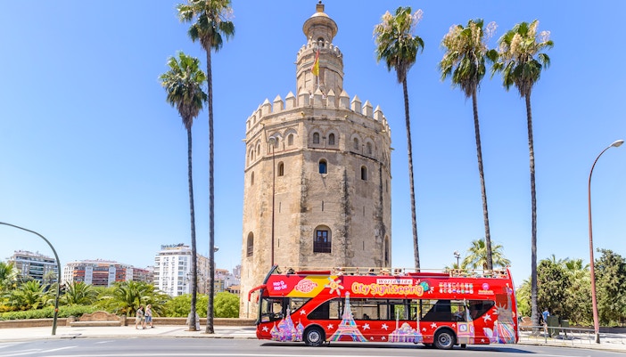 Hop-On-Hop-Off bus in front of Torre del Oro, Seville.