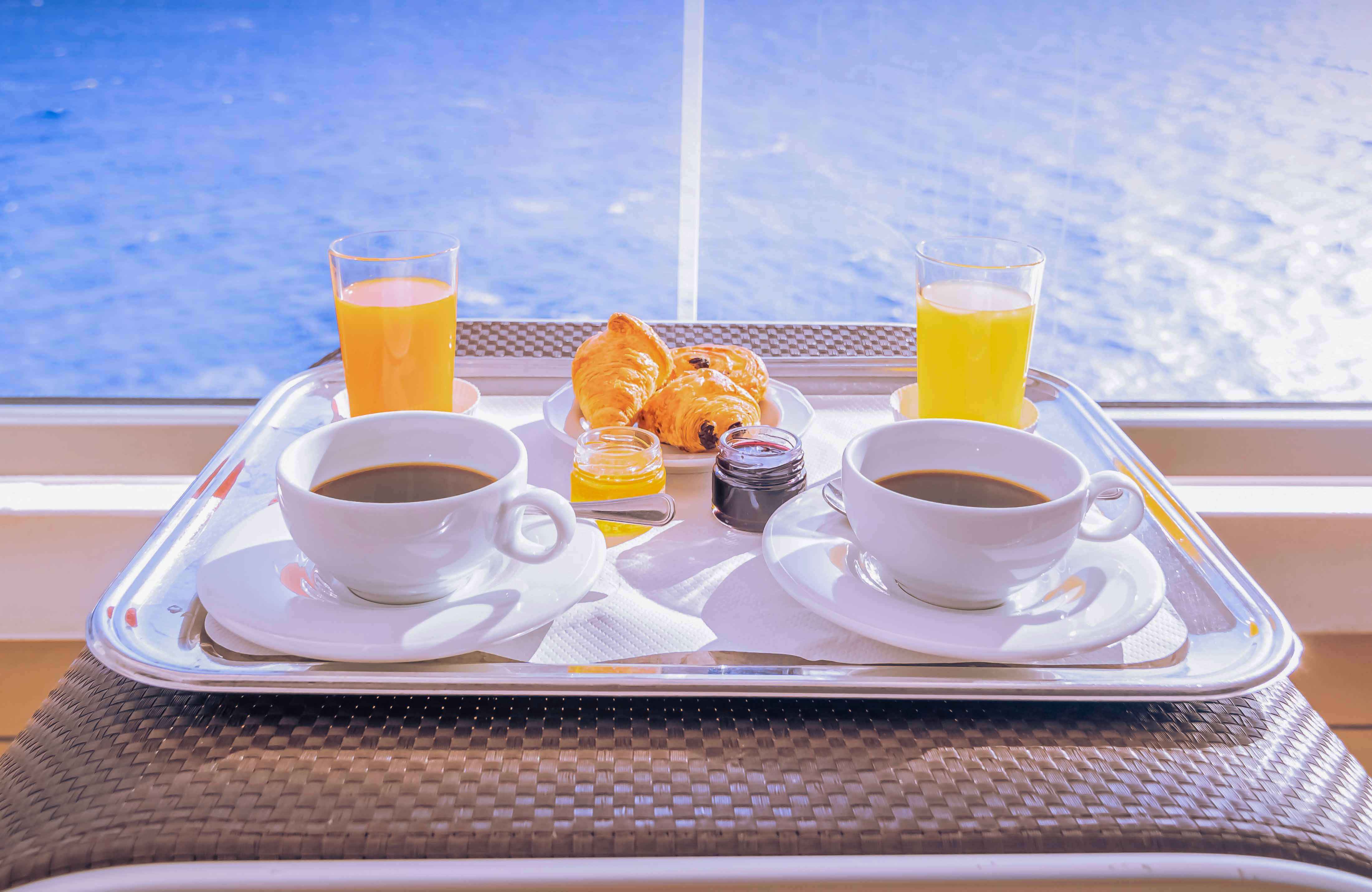 Breakfast tray with coffee, juice, and pastries on a Thames lunch cruise.