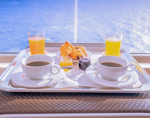 Breakfast tray with coffee, juice, and pastries on a Thames lunch cruise.