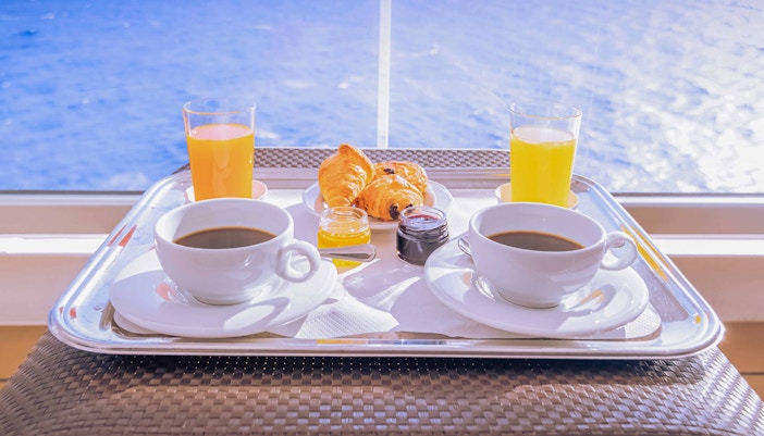 Breakfast tray with coffee, juice, and pastries on a Thames lunch cruise.