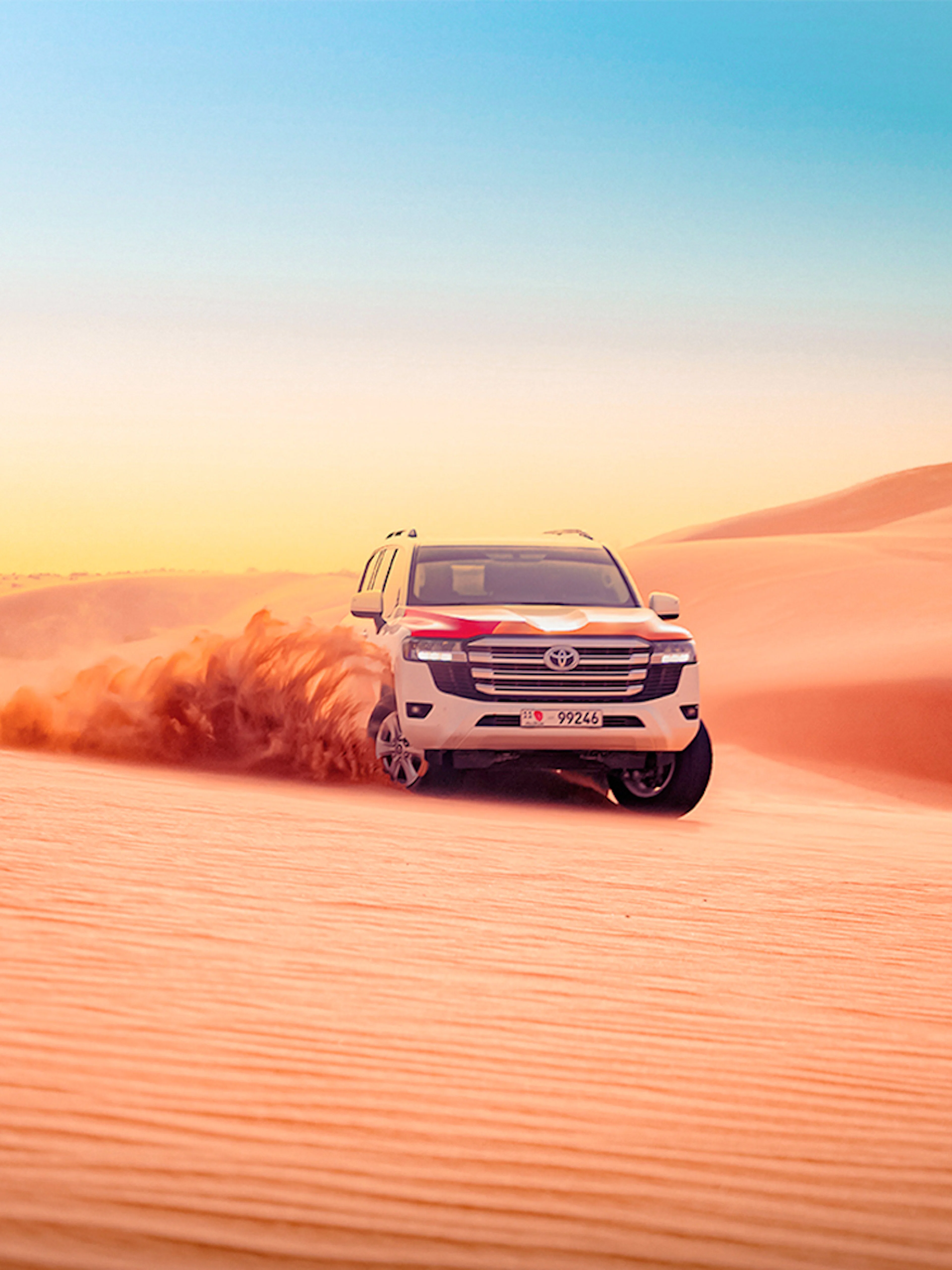 SUV driving through sand dunes during Abu Dhabi desert safari.