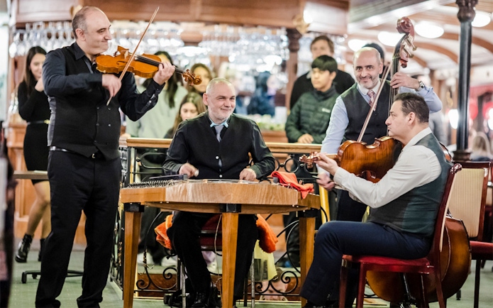 Rajk Folk Orchestra performing on a Danube dinner cruise at night.