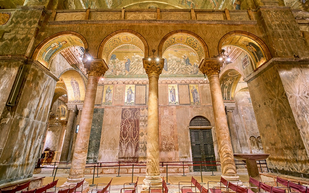 Interior of St. Mark's Basilica with ornate columns and mosaics, Venice.