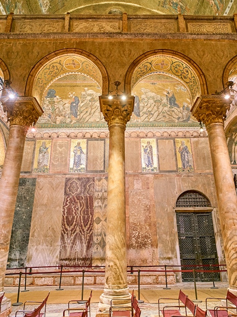Interior of St. Mark's Basilica with ornate columns and mosaics, Venice.