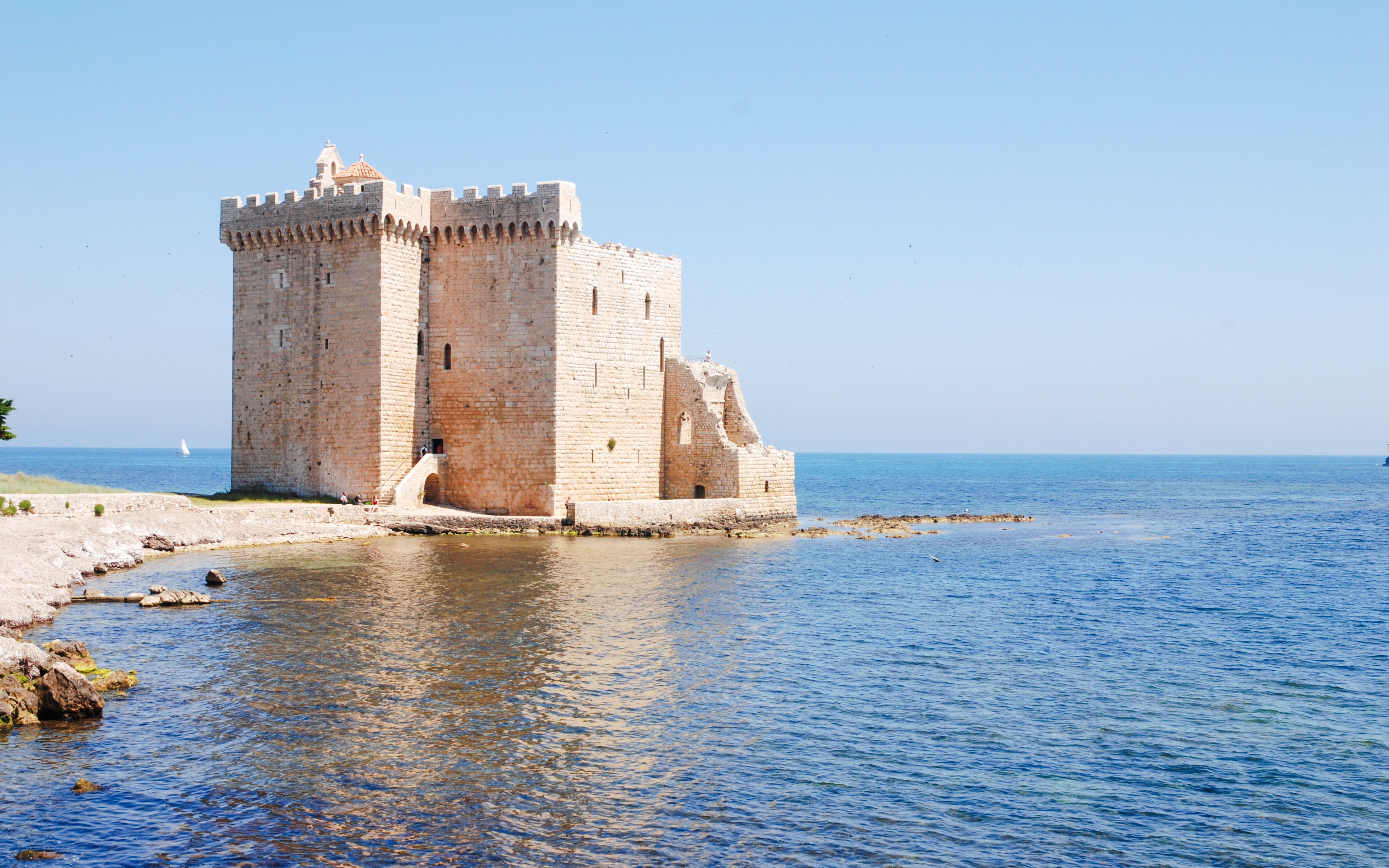 Stone fortress on Île Saint-Honorat, Cannes, France, surrounded by blue sea.