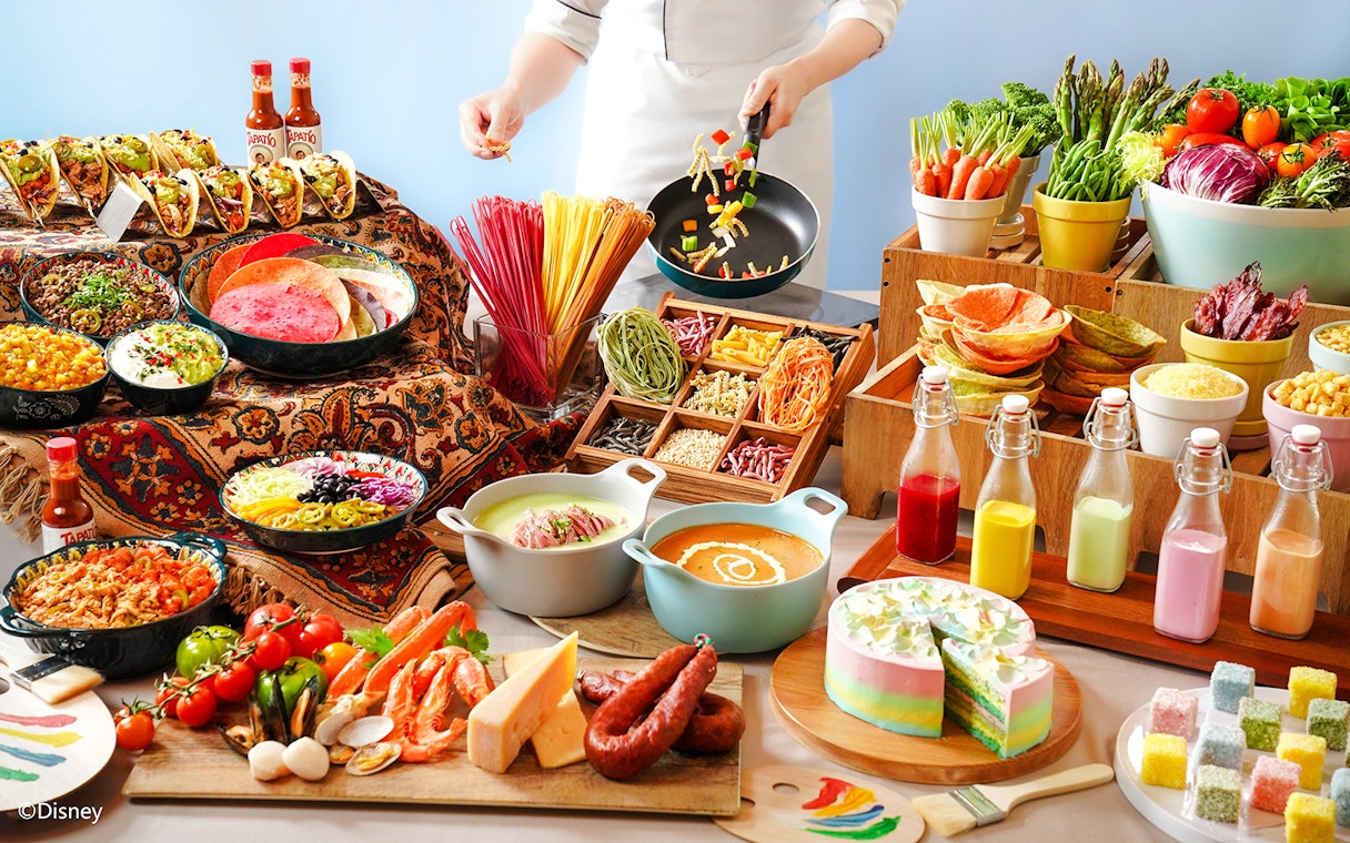 Buffet spread with tacos, colorful pasta, fresh vegetables, and desserts at Disneyland Hong Kong.