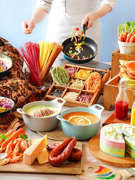 Buffet spread with tacos, colorful pasta, fresh vegetables, and desserts at Disneyland Hong Kong.