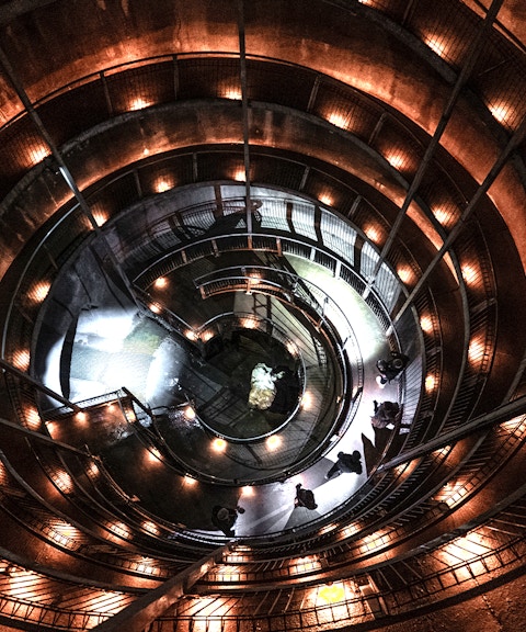 Spiral walkway inside Ruakuri Cave, New Zealand, illuminated with warm lights.