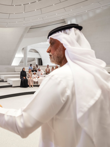 Bird show at Zayed National Museum, Abu Dhabi with audience seated in modern amphitheater.