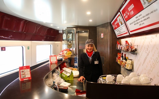 Train cafe with staff member and snacks on Italy train journey.