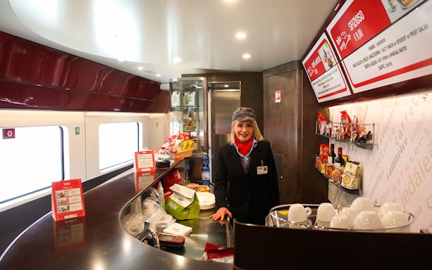 Train cafe with staff member and snacks on Italy train journey.