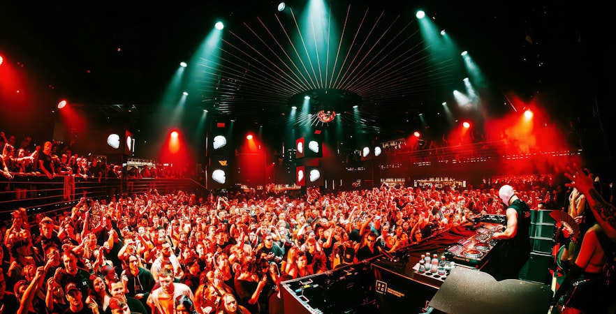 DJ performing at EPIC Club Prague after party with vibrant crowd and lights.